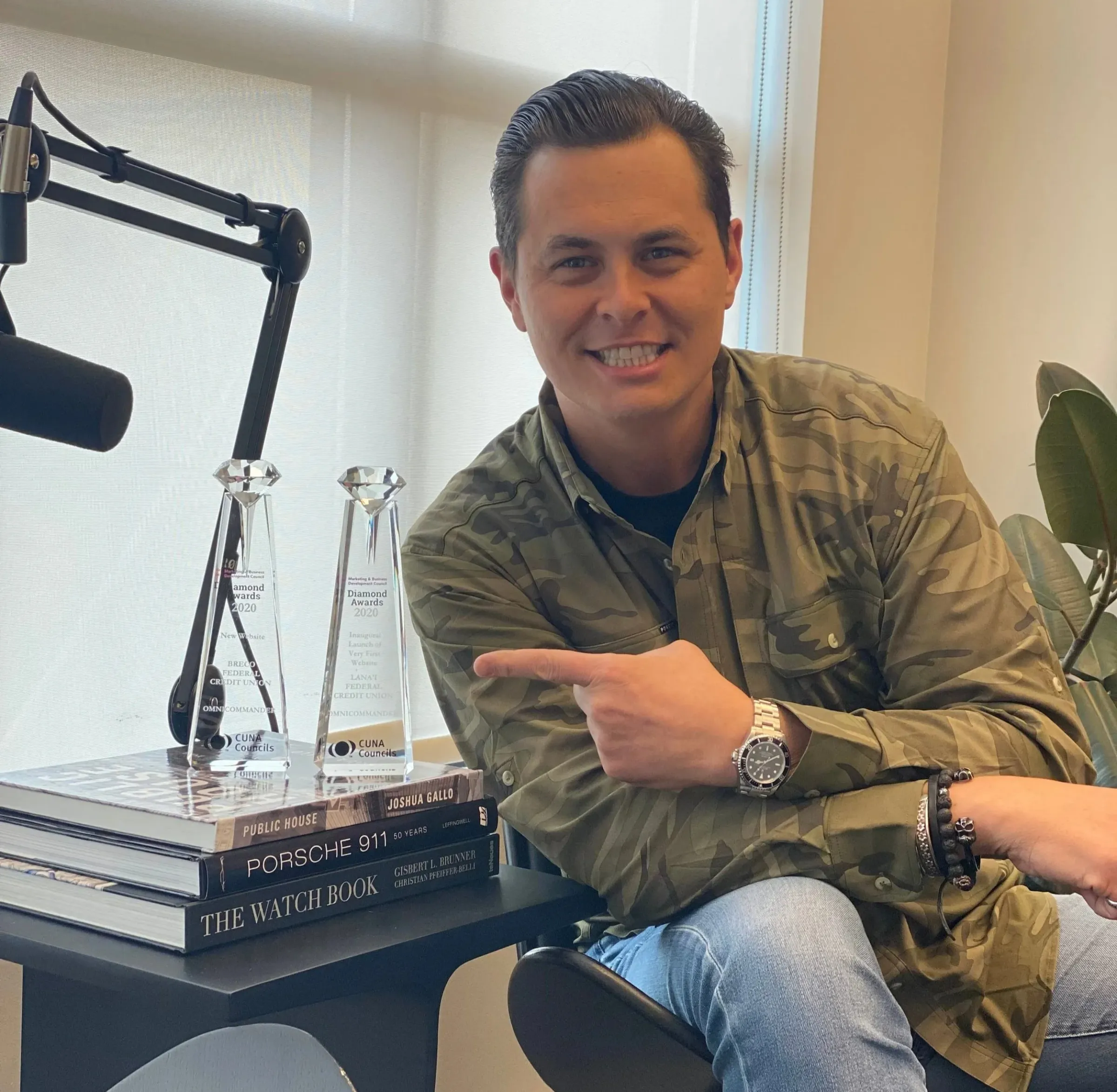 Eric Isham with his podcast microphone and industry awards